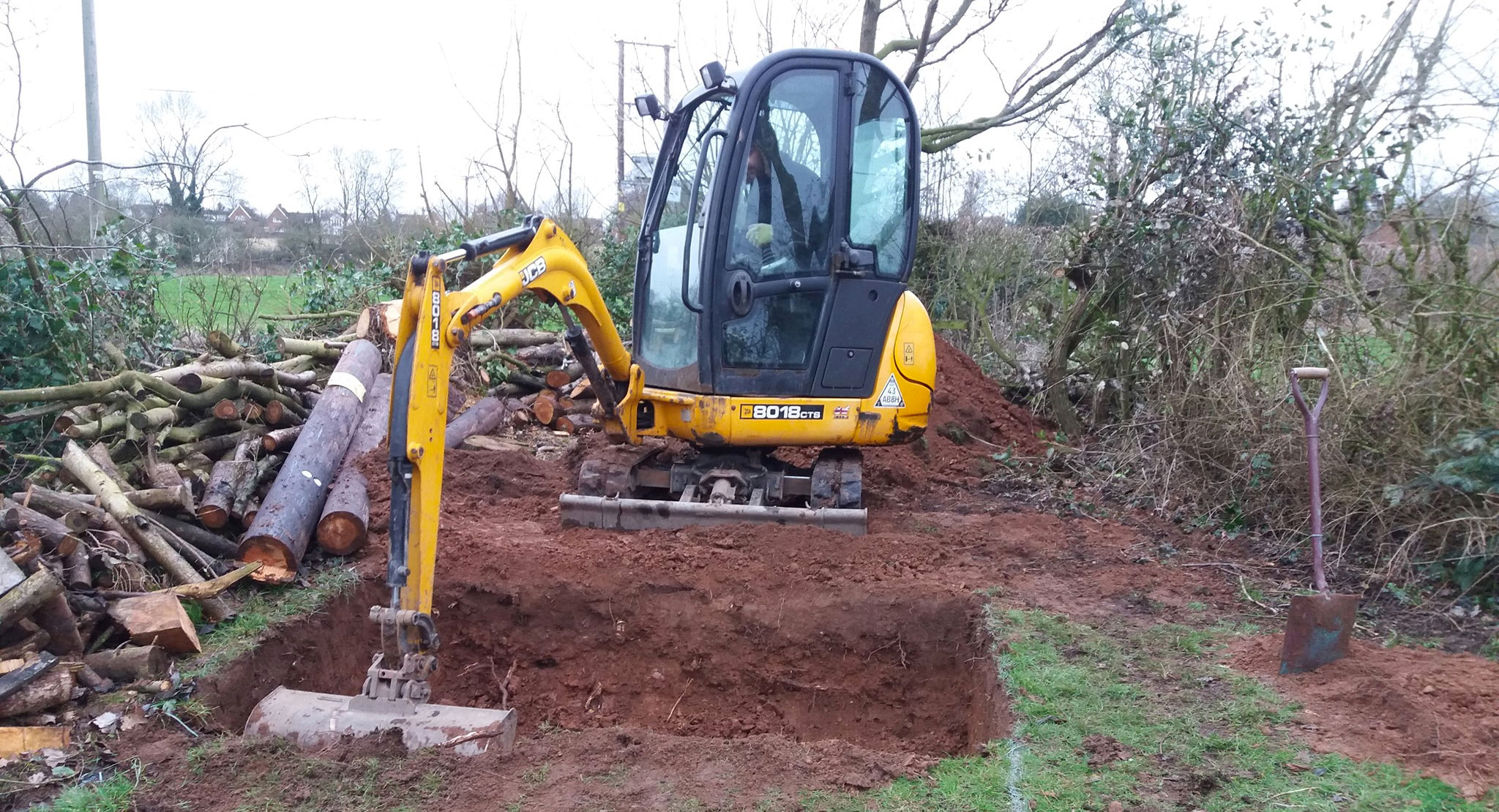 Mini digger excavating hole