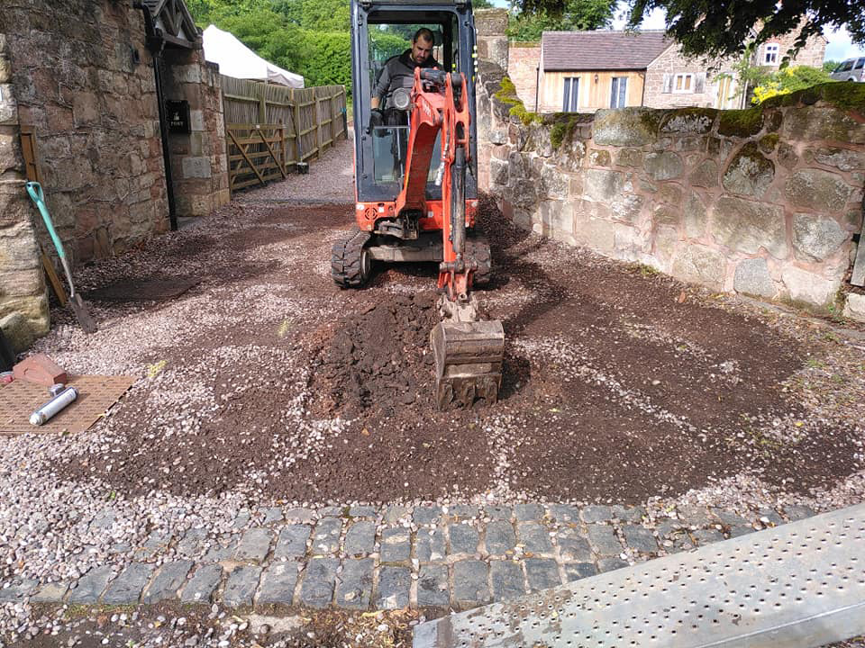 mini digger clearing gravel