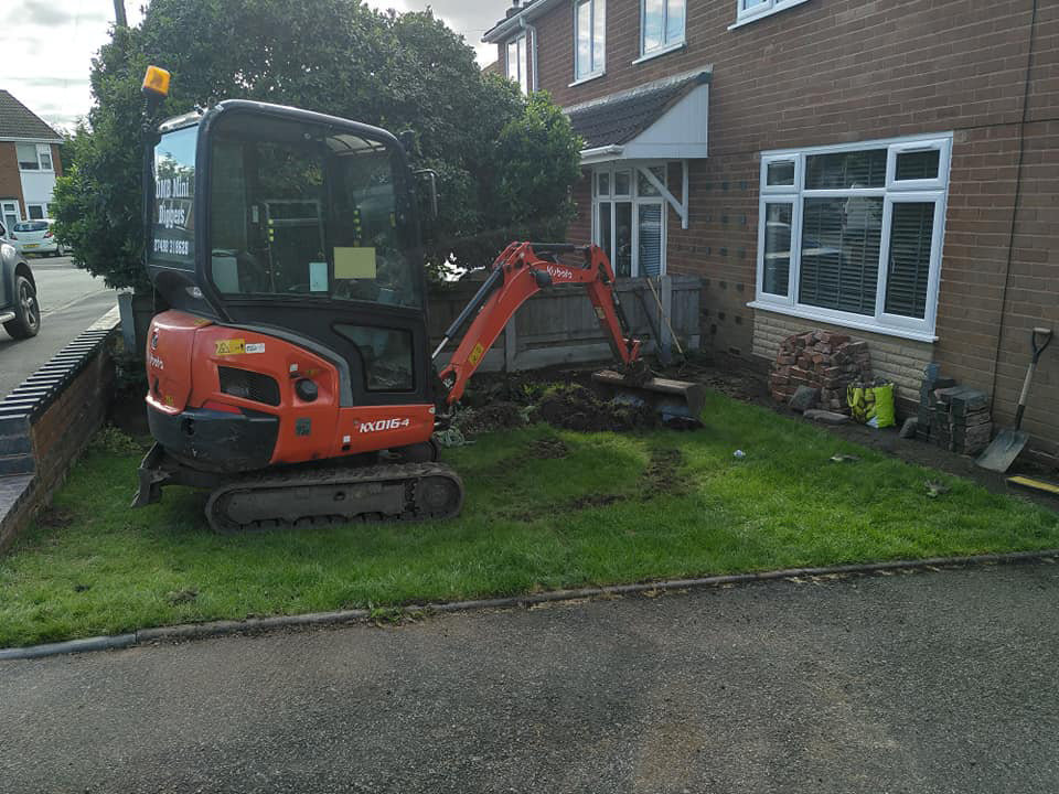 Mini digger clearing garden