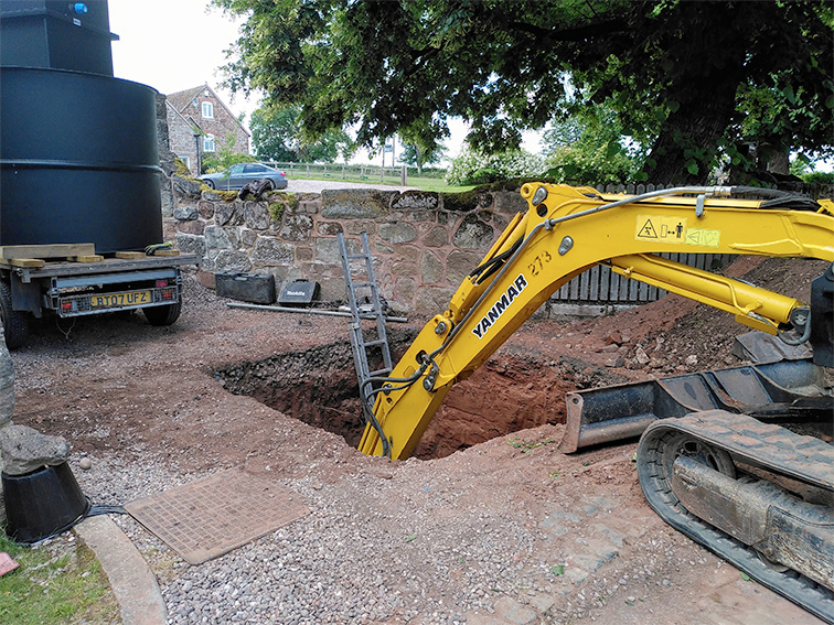 Digger excavating tank hole